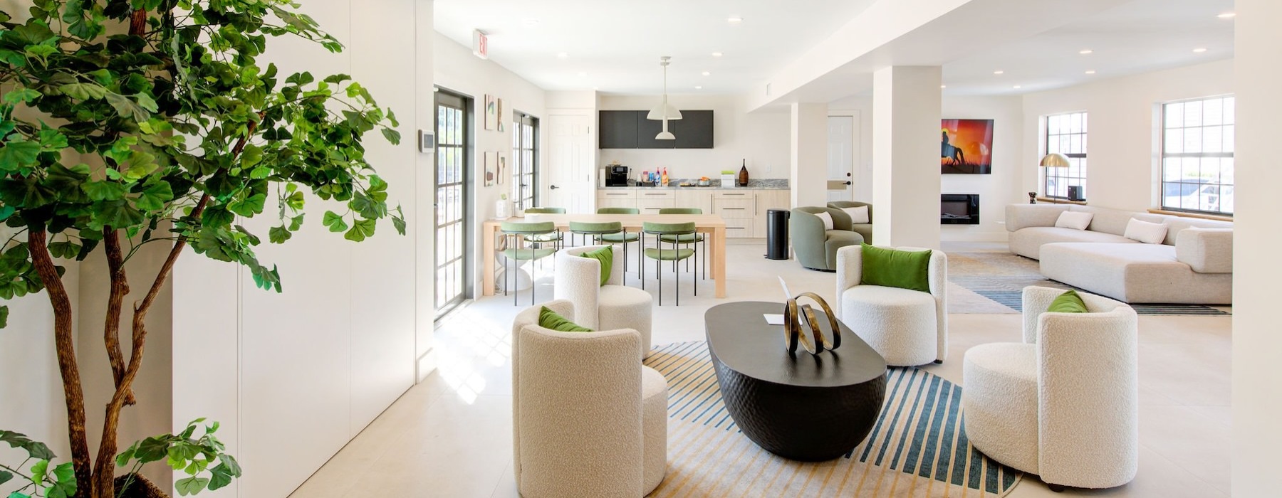 a large living room with a large white floor and a large tree