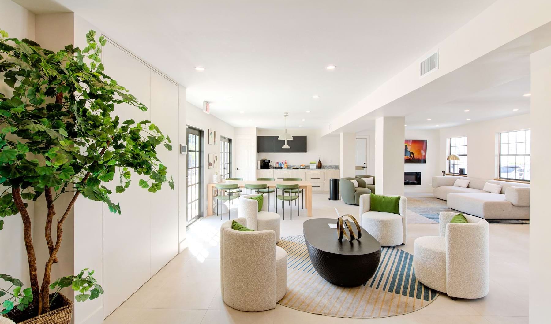 a large living room with a large white floor and a large tree