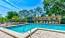 a swimming pool with a deck and trees in the background